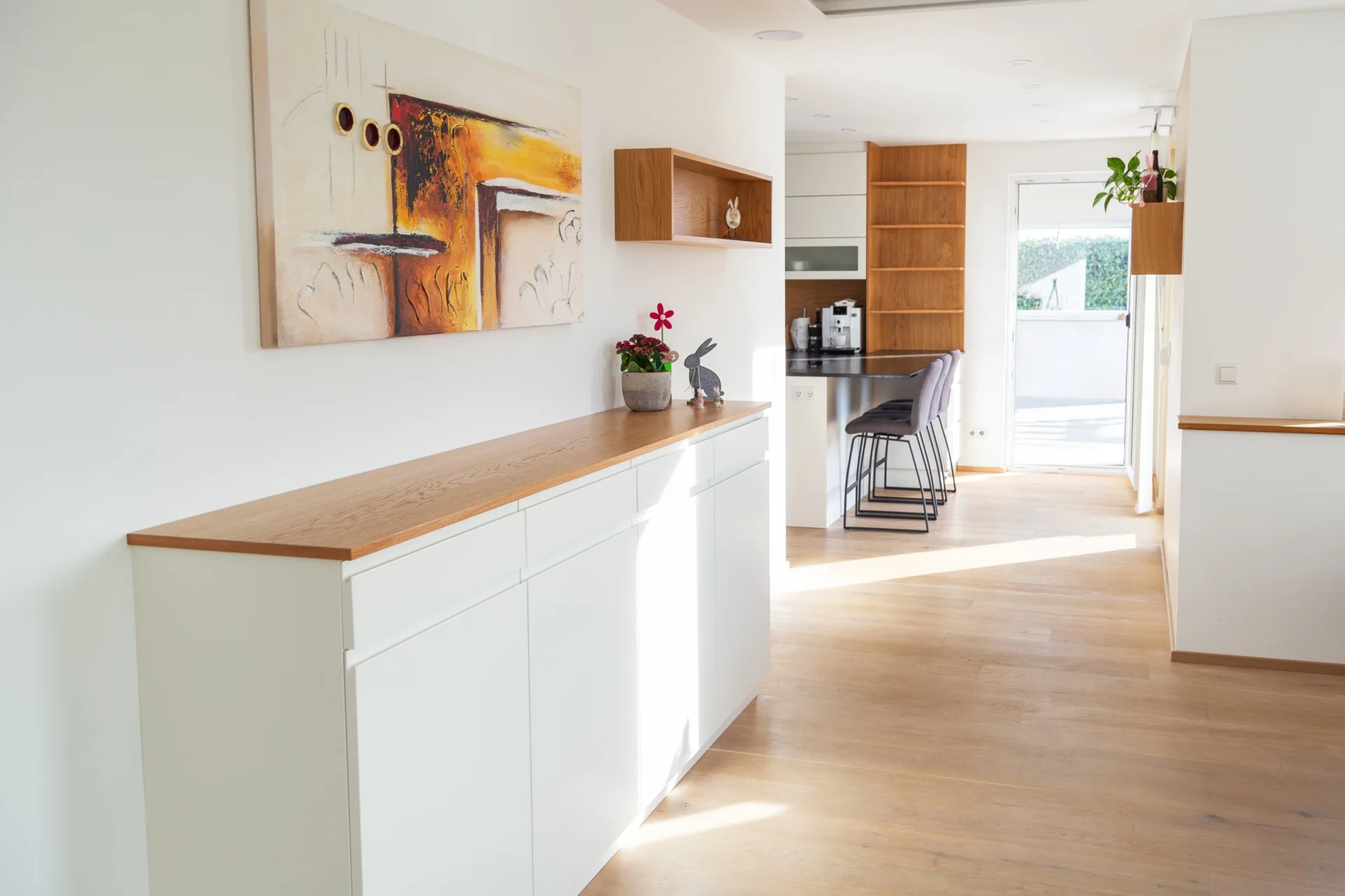 Wohnzimmer mit Möbeln vom Tischler, darunter eine Kommode in weiß mit Holzplatten