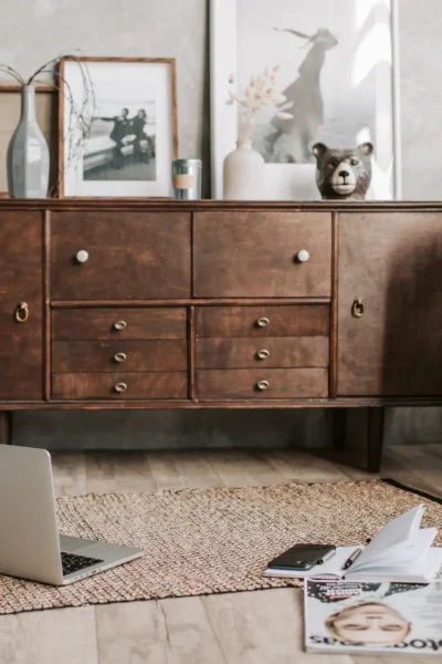 moebel Wohnzimmer mit rustikalen Möbeln, am Boden ist ein Laptop mit Büchern